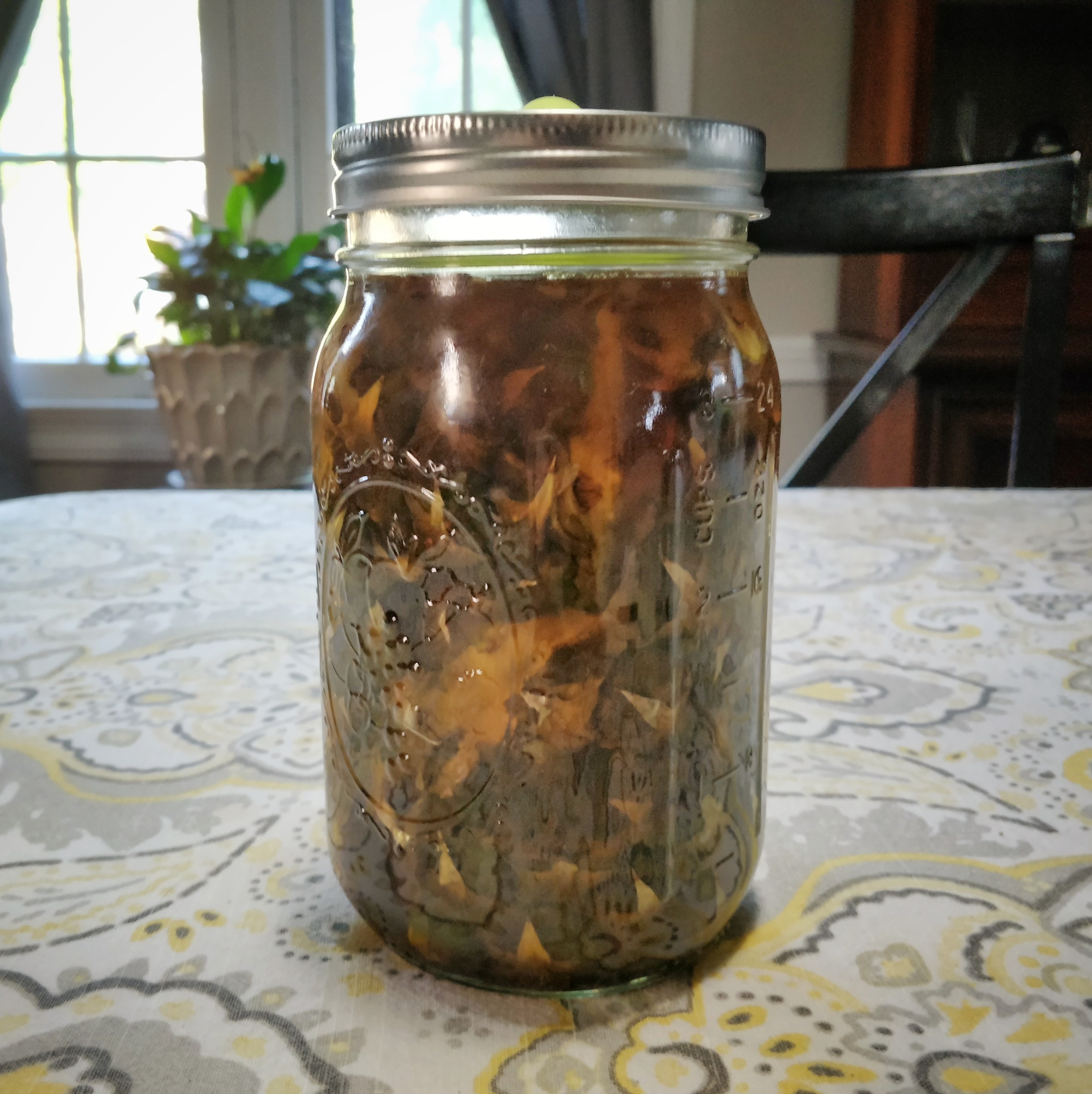 Pineapple cuttings in a jar of dark liquid.