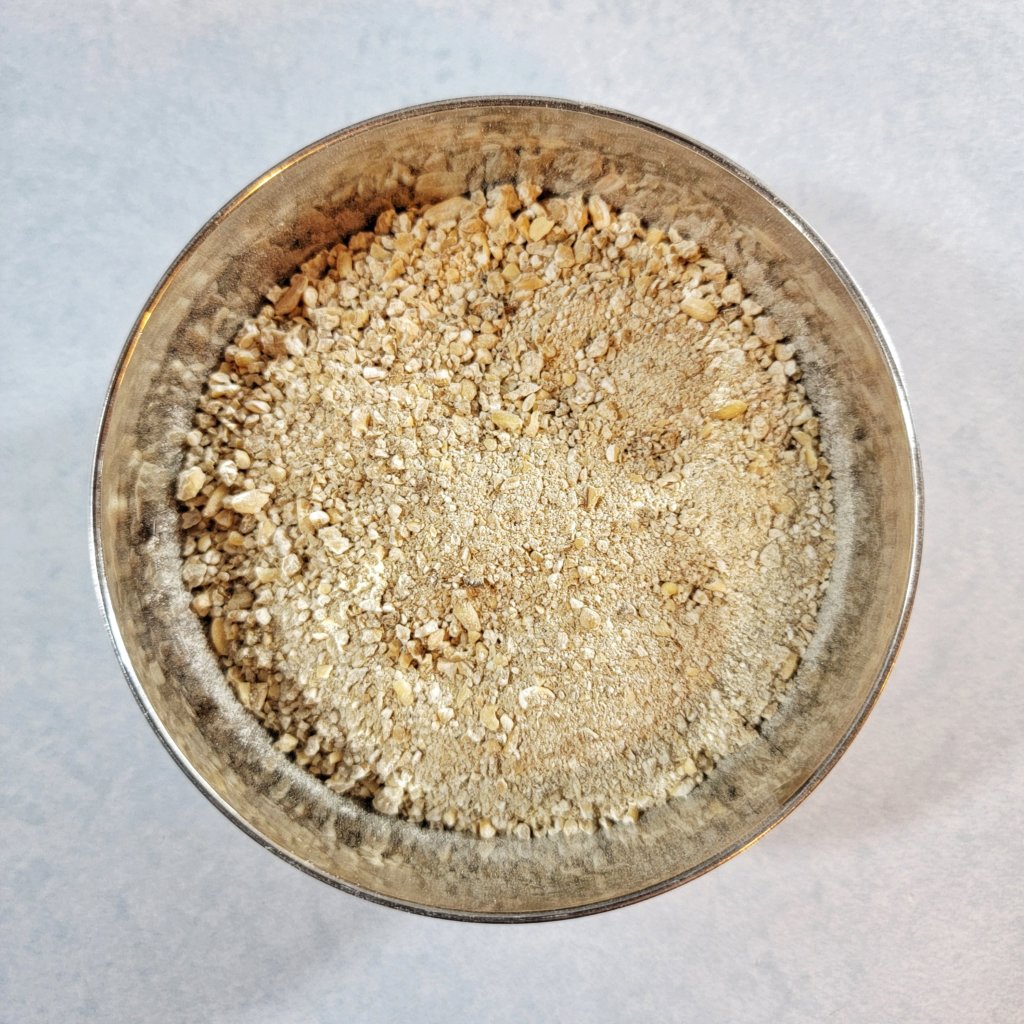 A bowl of nuruk, mostly powder with some visible chunks of grain.
