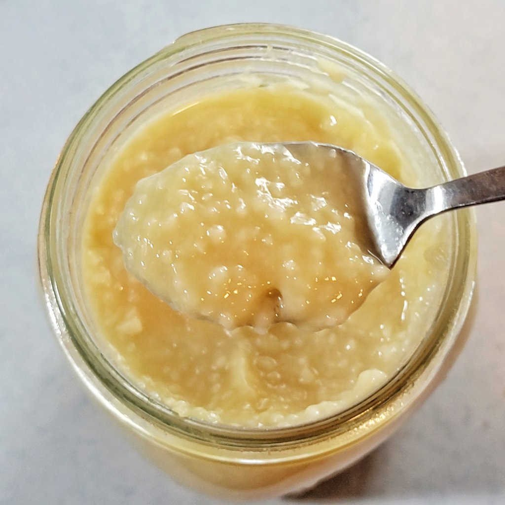 Closeup of a spoonful. Very glossy, lumpy, and a rich yellow.