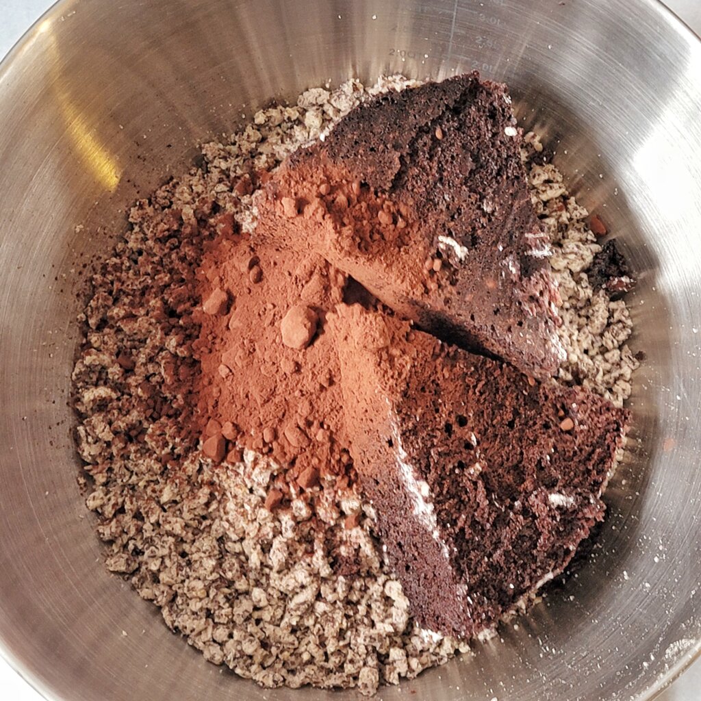 A bowl with ground adzuki beans, chocolate cake, and cocoa powder, unmixed.