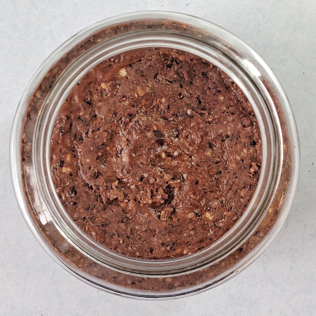 Top-down view of the jar filled with miso. The surface has a smooth, pebbly look.