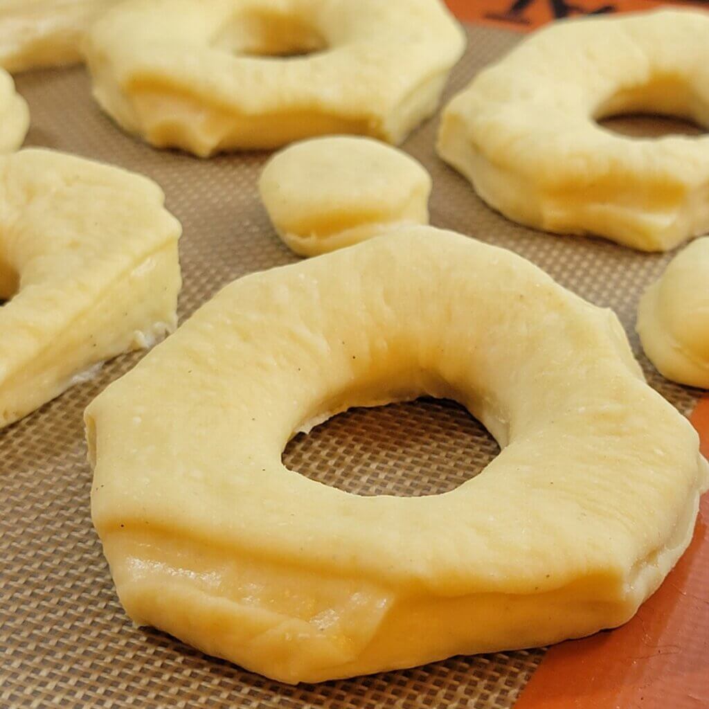 Donuts cut and proofing before being fried. They are octagonal and a little uneven because they're homemade!